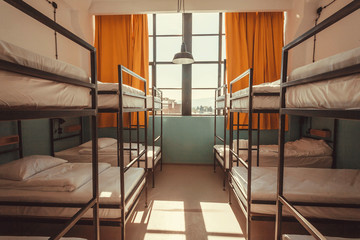 Window in bedroom of a youth hostel with clean beds for relaxing tourists and students - obrazy, fototapety, plakaty