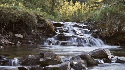 Fototapeta na wymiar Small waterfall in forest with creek