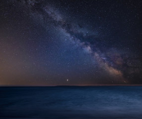 Vibrant Milky Way composite image over landscape of Beautiful long exposure beach