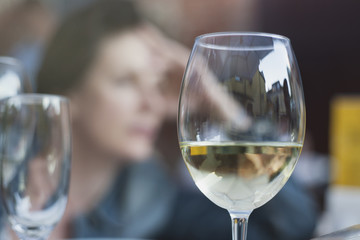 glass of white on the background of thinking black-haired girl