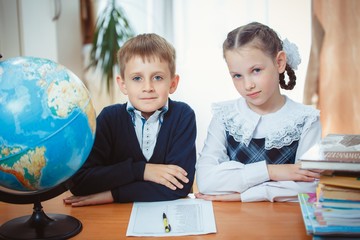 Schoolboy and schoolgirl with a globe