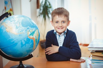 A schoolboy sits at a desk
