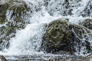 Close up of Flowing water on some rocky stream