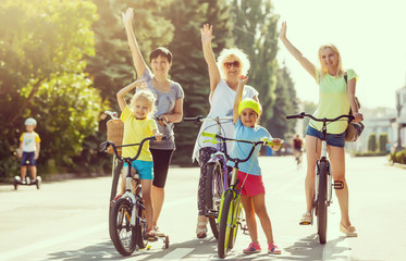 Obraz premium Group of people joining their hands while holding their bicycles