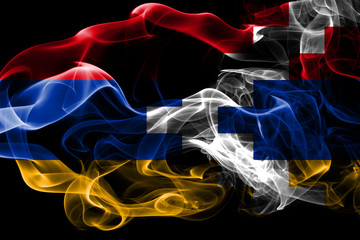 National flag of Artsakh made from colored smoke isolated on black background. Abstract silky wave background.