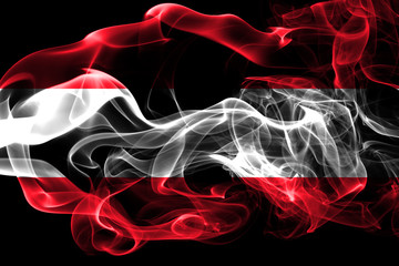 National flag of Austria made from colored smoke isolated on black background. Abstract silky wave background.