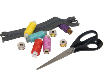 colored thread and scissors on a white background. items for embroidery