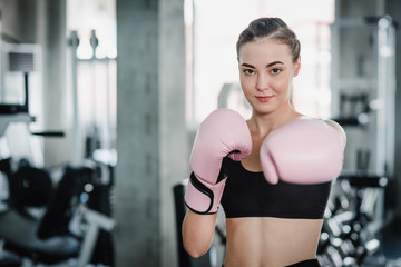 Fototapeta premium Woman with pink boxing gloves in gym