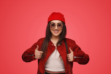 Stylish woman with thumbs up in studio