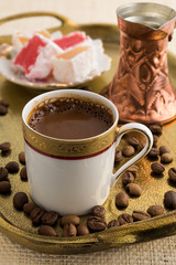 Vintage cup of turkish coffee and turkish delights served in bronze tray on natural matting