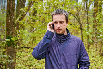 man is talking on the phone in the woods