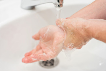 Fototapeta premium Young woman washing her hands