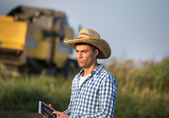 Farmer with combine harvester in field