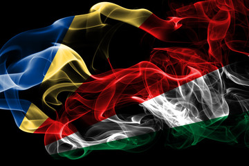 National flag of Seychelles made from colored smoke isolated on black background. Abstract silky wave background.
