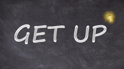 Get up text on blackboard with light bulb