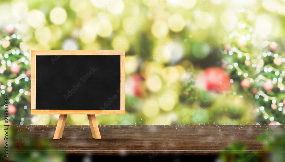 Aufkleber blackboard on dark brown wood table top with abstract blur christmas tree red decor ball and snow fa