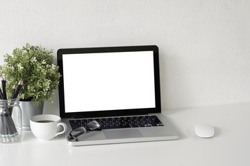 Fototapeta premium Workspace Mock up laptop computer on white table with mug of coffee, plat in pot and notebook paper copy space office table.