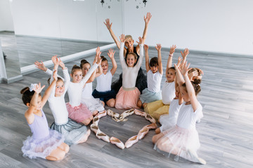 Group of beautiful little girls practicing ballet at dancing class.