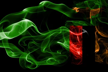 Foto op Aluminium National flag of Zambia made from colored smoke isolated on black background. Abstract silky wave background. © Vlad