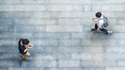 Aerial top view with blur man with smartphone walking converse with busy city crowd move to...
