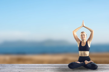 Fototapeta na wymiar Young attractive smiling woman practicing yoga, sitting.Young beautiful woman practicing yoga and gymnastic. Wellness concept in gym