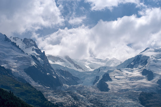 Dome and Aiguille du Gouter mountain peaks with Bossons Glacier in the European Alps, a summer snowy landscape.