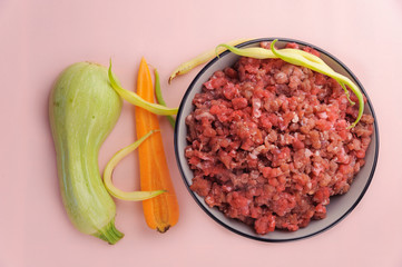 Natural raw ingredients for pet food on pink background. Flat lay.