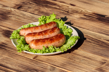 Grilled sausages on wooden table