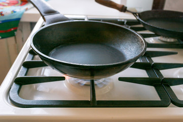 black cast-iron pan is on a gas stove, close up