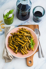 wholemeal pasta with basil pesto in dish on table with red wine. light Mediterranean dish. vegan healthy food