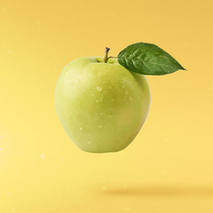 fresh apple Flying in air over yellow background