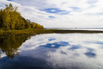 Aerial view over forest and lake during vibrant autumn colors