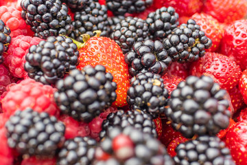 Mixed berries raspberries, strawberries, blackberries so close, focus close-up with shallow depth of field, background