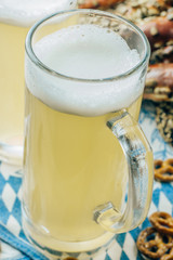 Rustic background for Oktoberfest or Bavarian specialties with white and blue fabric, , beer glass and pretzels on wooden table. Menu card for Restaurants