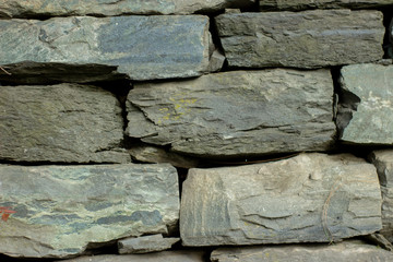 Dark grey block rocks textured wall background.