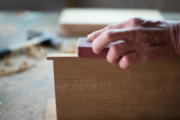 Human hand carpenters who are polished wood finishing in the tra