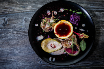 top view of tasty decorated meal on black restaurant plate