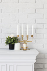 Gold candle holder on artificial fireplace