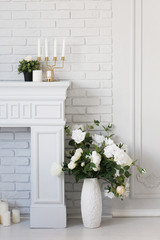 Fireplace with candle holder and vase of flowers