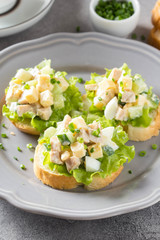 Sandwiches with squid meat salad, cucumber, egg, cheese and mayonnaise. Canapes in tartlets, Russian snack. Delicious food for Breakfast