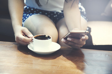 Woman with cup of coffee and phone