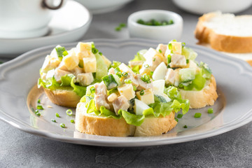 Sandwiches with squid meat salad, cucumber, egg, cheese and mayonnaise. Canapes in tartlets, Russian snack. Delicious food for Breakfast