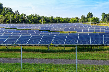 Solar panel on blue sky background. Green grass and cloudy sky.