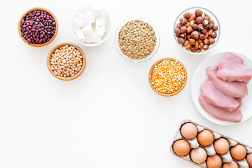 Healthy food. Products rich protein and fiber. Legumes, nuts, low-fat cheese, meet, eggs. Raw beans, chickpeas, lentil, almond, hazelnut on white background top view copy space