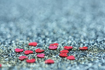 Blue glitter background with little red hearts.