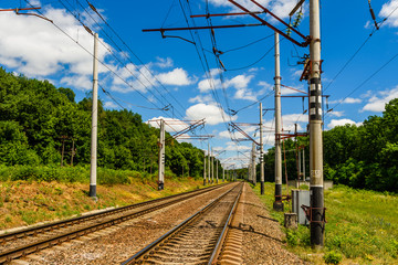 View on a railroad track and white clouds in blue sky