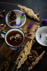 Obraz na płótnie Canvas Tea with edible flowers, pansies. The concept of a cozy home autumn tea party