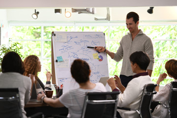 Business man giving presentation on future plans to his colleagues at office