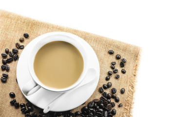 Cup of fresh coffee with coffee beans on burlap warm cup on brown background top view with free space for text