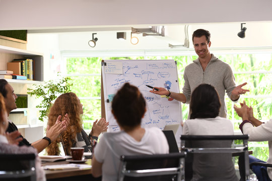 Business man giving presentation on future plans to his colleagues at office